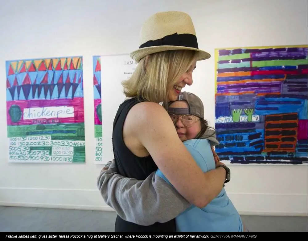 Franke James (left) gives sister Teresa Pocock a hug at Gallery Gachet, where Pocock is mounting an exhibit of her artwork. GERRY KAHRMANN / PNG